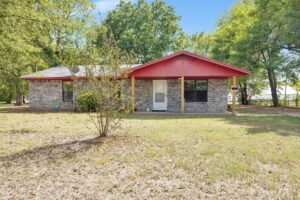 Front exterior view of a charming 3-bedroom, 2-bathroom home for sale at 805 W 1st St, Hugo, Oklahoma.