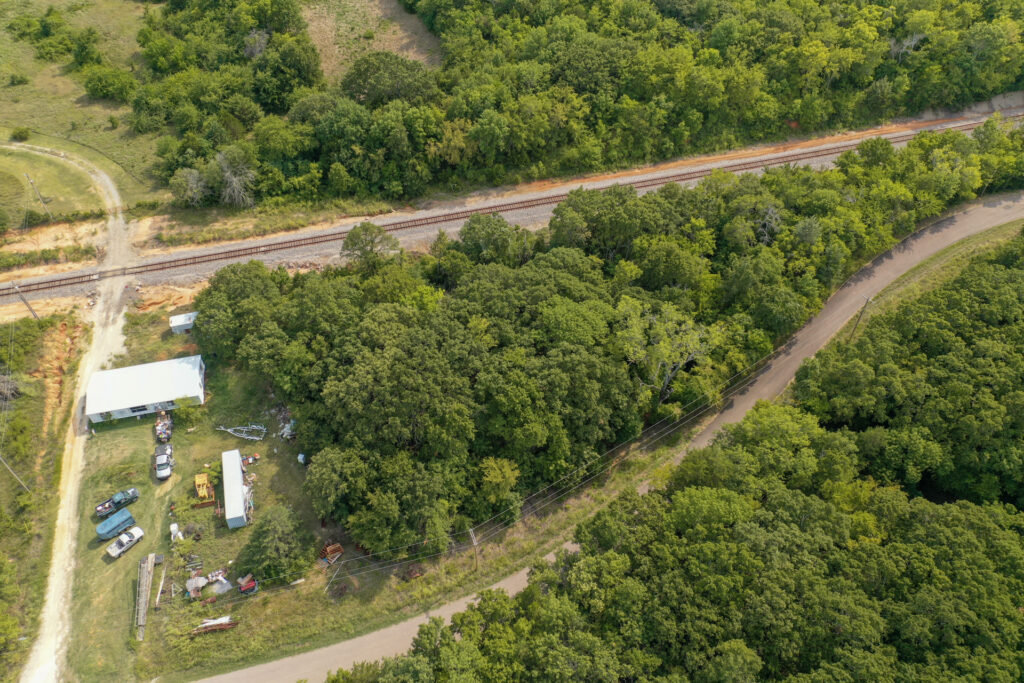 Aerial view of a 1.3-acre lot surrounded by trees near Lake Texoma in Mead, Oklahoma, perfect for building a lake house.