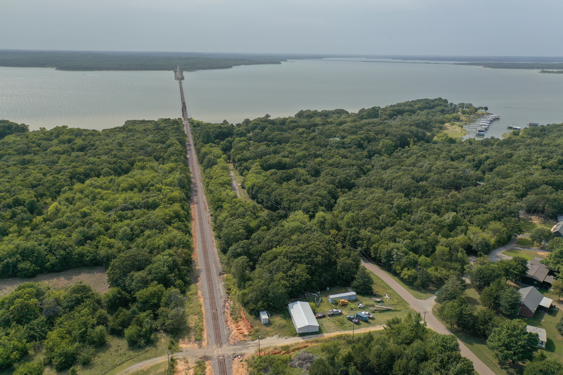 Aerial view of a 1.3-acre lot surrounded by trees near Lake Texoma in Mead, Oklahoma, perfect for building a lake house.