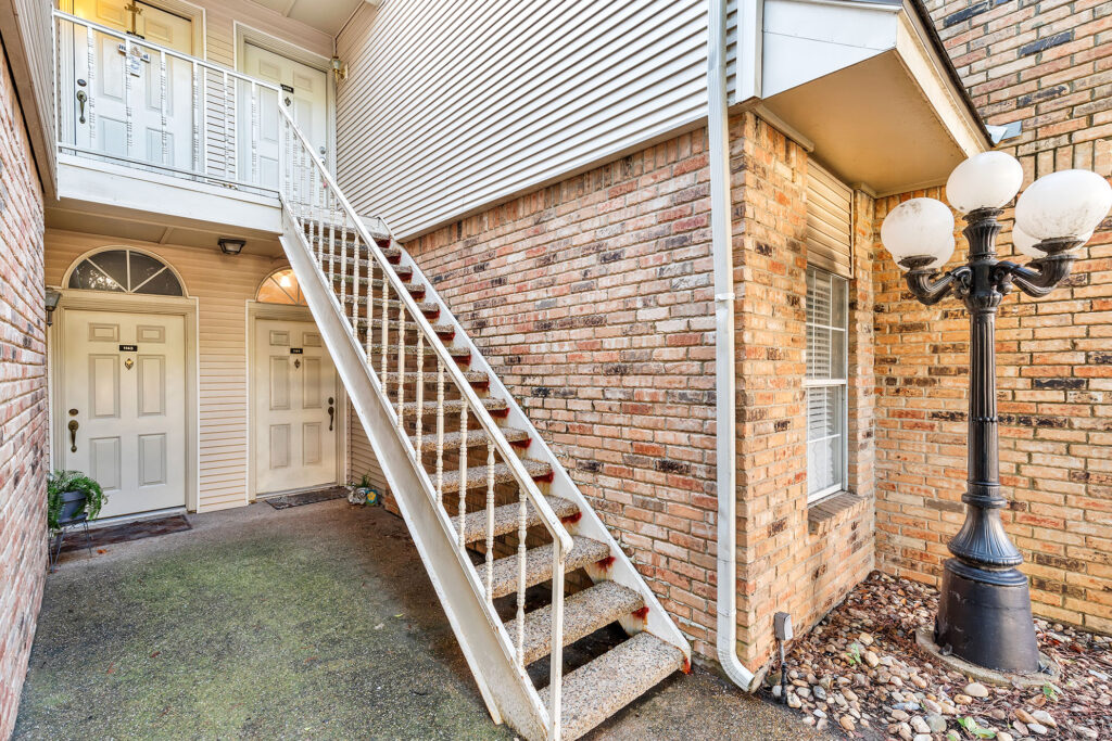 Beautifully updated 1-bedroom condo for sale in Addison, Texas, featuring a spacious balcony, vaulted ceilings, and a cozy fireplace.